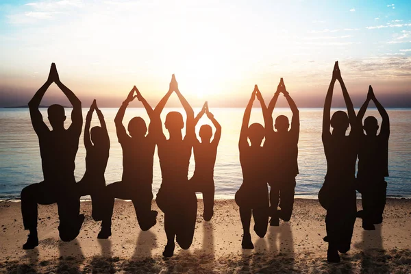 Silhouette Persone Che Fanno Yoga Sulla Spiaggia Sabbia Tramonto — Foto Stock