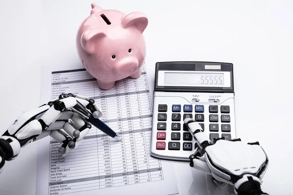 机器人检查财务报告的特写与计算器在桌面上 — 图库照片