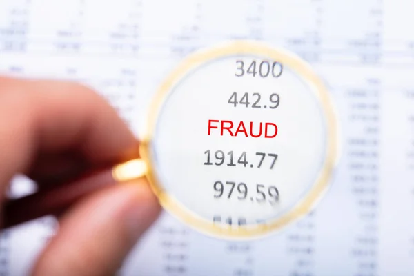 Man Hand Examining Fraud Word Financial Report Magnifying Glass — Stock Photo, Image