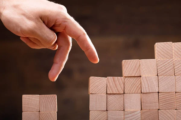 Close Person Stepping Finger Stacked Wooden Blocks — Stock Photo, Image