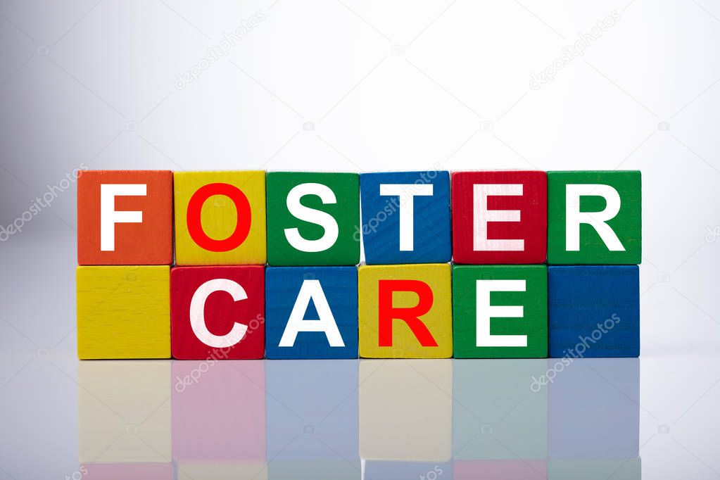 Close-up Of Foster Care Cubic Blocks On Reflective Background