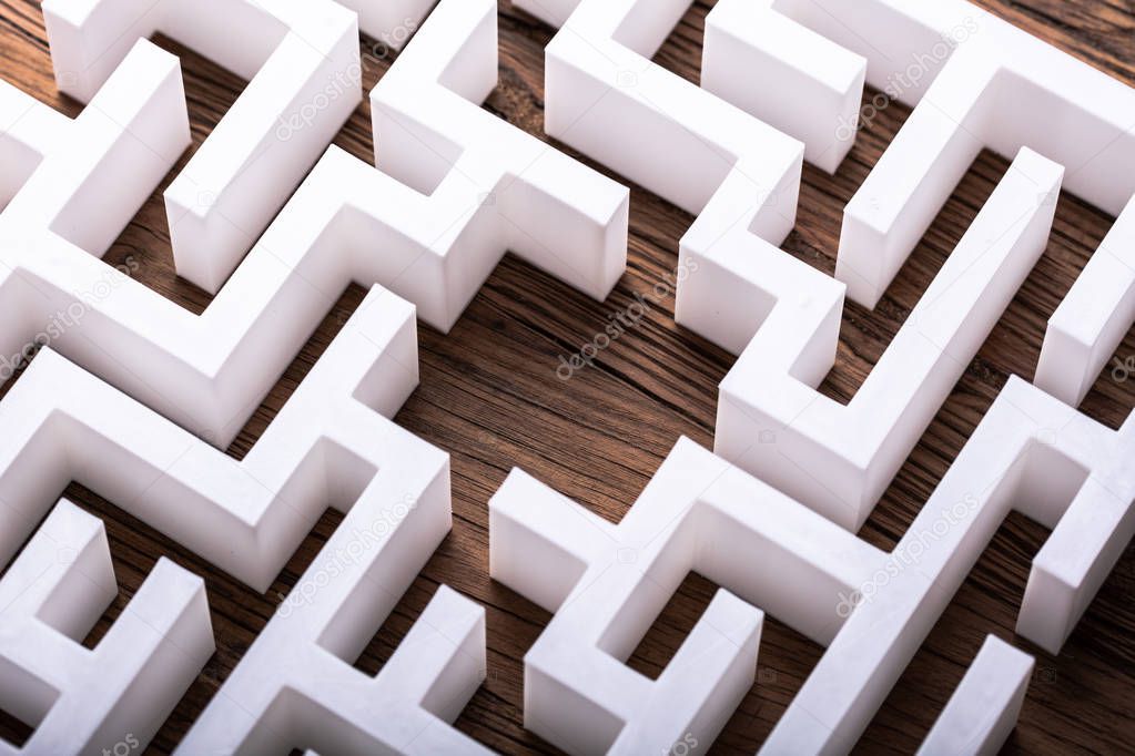 Overhead View Of Abstract White Maze On Wooden Background