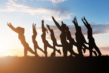 Gece karanlığında dramatik gökyüzü karşı Yoga yapan insanlar silüeti