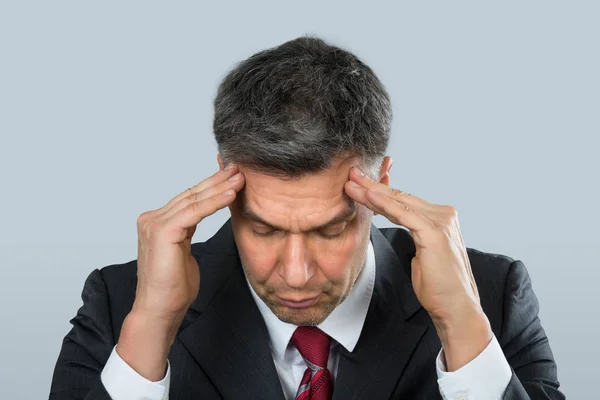 頭痛に苦しんで成熟したビジネスマンのクローズ アップ — ストック写真