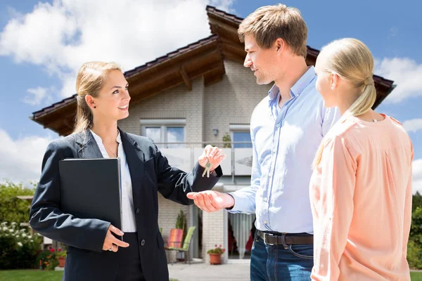 Smiling Female Real Estate Agent Giving Key New House Young — Stock Photo, Image