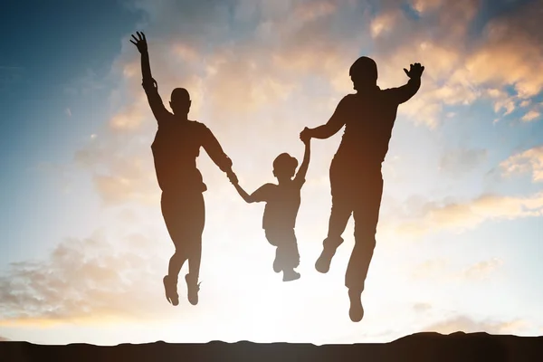 Silhouette Della Famiglia Che Salta Aria Contro Cielo Drammatico — Foto Stock