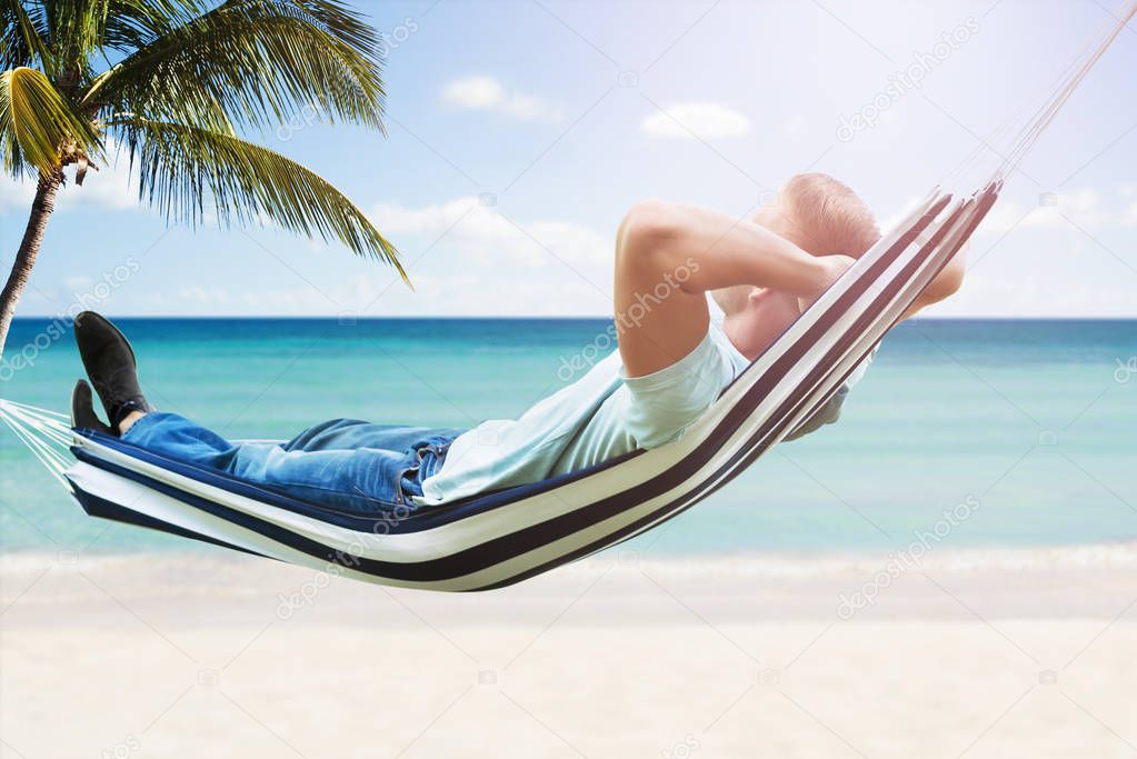 Man Relaxing In Hammock At Tropical Beach