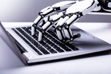 Resepsiyon üzerinde dizüstü bilgisayar kullanarak bir robot el Close-up