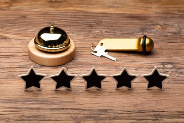 Hizmet Bell ve ahşap arka plan üzerinde siyah beş yıldızlı Rating simgesinin yanında otel anahtarı