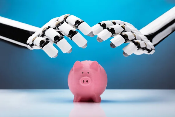 Robotic Hand Skyddar Rosa Piggybank Över Reflekterande Skrivbord — Stockfoto