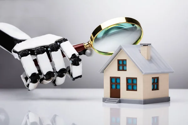 Robotic Hand Examining House Model Magnifying Glass — стоковое фото
