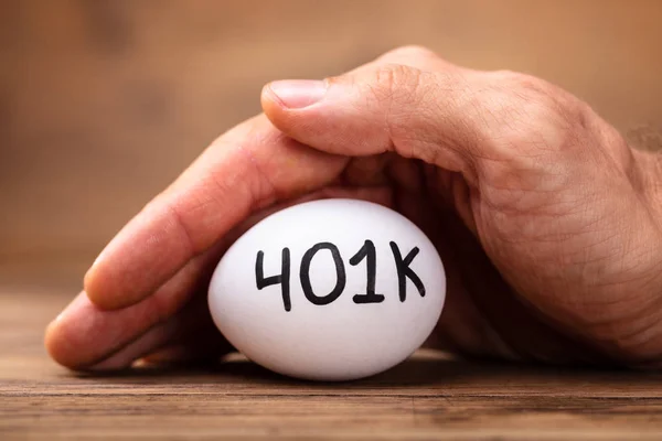 男子的手特写保护401K 白鸡蛋 — 图库照片