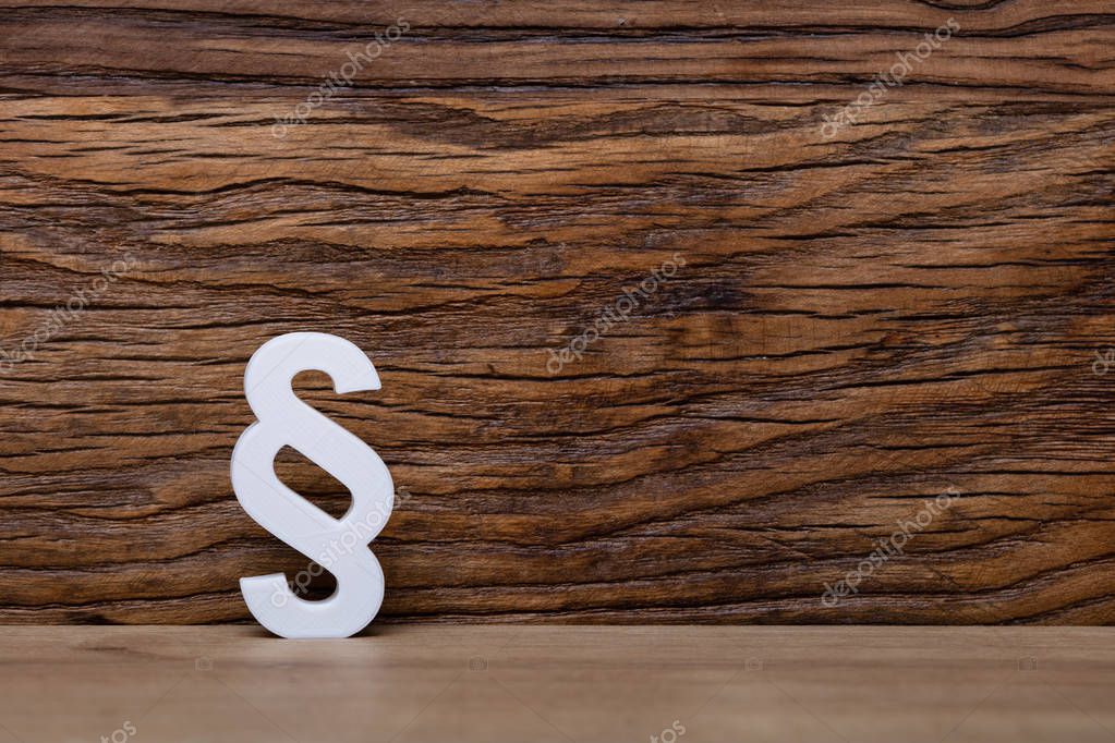 White Paragraph Sign Leaning On Wooden Wall