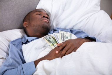 Afrika adam yatakta para birimi notlar bohça ile uyku