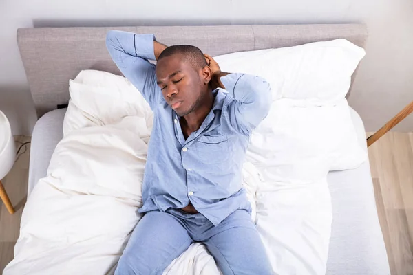 Сломанный Вид Спящего Молодого Человека Сидящего Кровати — стоковое фото