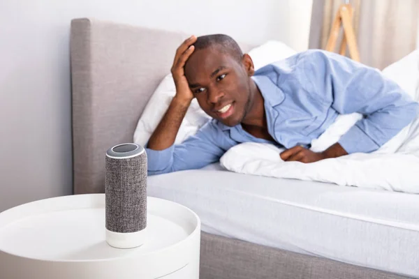 African Man Leżący Łóżku Słuchając Muzyki Bezprzewodowy Głośnik — Zdjęcie stockowe