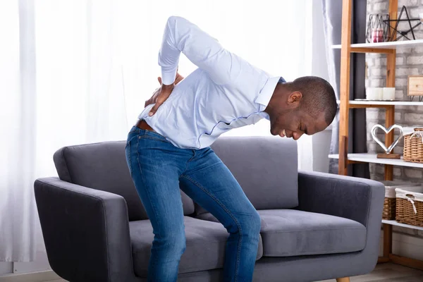 Young Man Pain Holding His Back Front Sofa — Stock Photo, Image