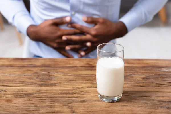 Gelas Dari Susu Pada Meja Kayu Depan Manusia Yang Menderita — Stok Foto