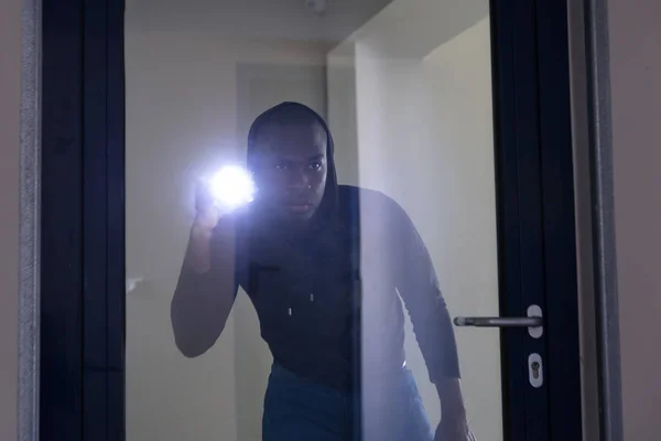 Ladrão Olhando Através Porta Vidro Com Lanterna — Fotografia de Stock