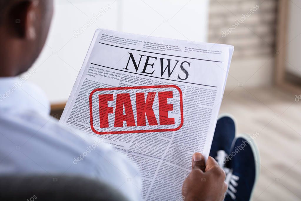 Close-up Of An African Man Holding Newspaper With Fake News