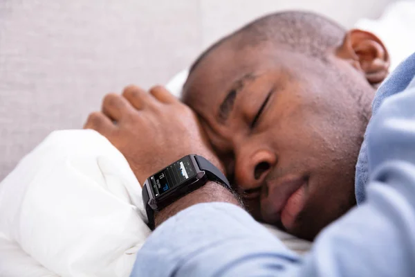 特写镜头的男人睡在他的手智能手表显示心跳率 — 图库照片