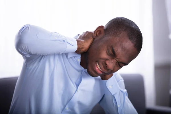 一个非洲年轻人颈部疼痛的特写 — 图库照片