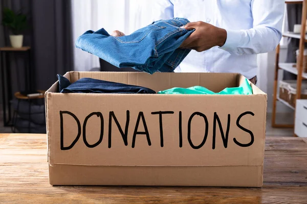 Afrikansk Man Sätta Kläder Donation Box — Stockfoto