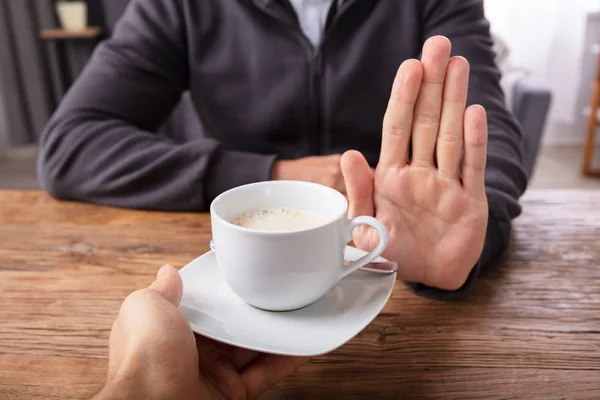 Close Man Hand Refusing Cup Coffee Offered Person Wooden Desk — Stock Photo, Image