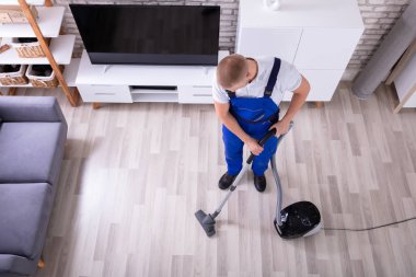 Erkek hademe yere elektrikli süpürge ile temizlik yüksek açılı görünüş