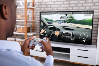 Televizyonda Joystick ile yarış oyunu oynayan Afrikalı bir adamın yakın çekimi