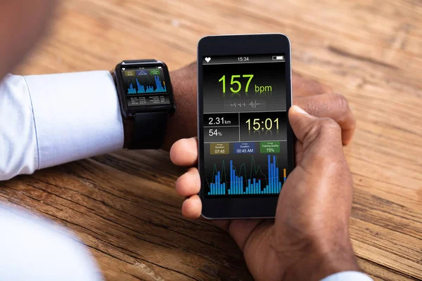 Mão Homem Com Smartwatch Monitoramento Celular Frequência Cardíaca Sobre Mesa — Fotografia de Stock