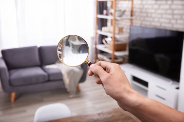 Close-up Of A Man's Hand Searching With Magnifying Glass At Home clipart