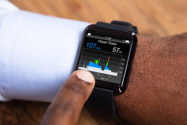 Kalp hızı gösterilen siyah Smartwatch kullanan bir adam Close-up