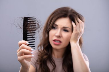 Endişeli bir kadın Hairloss acı tarak tutan Close-up
