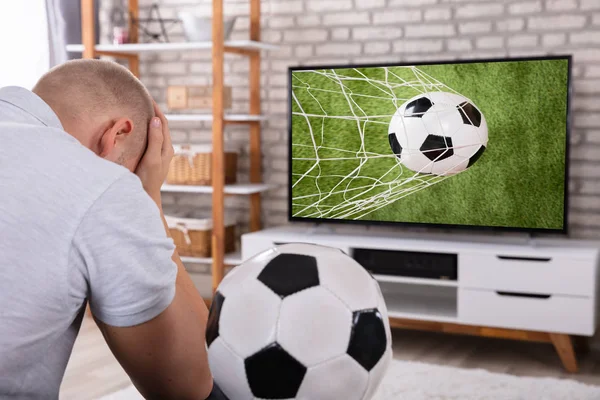 Печальный Человек Сидящий Рядом Телевизором Снимающий Футбольный Матч — стоковое фото