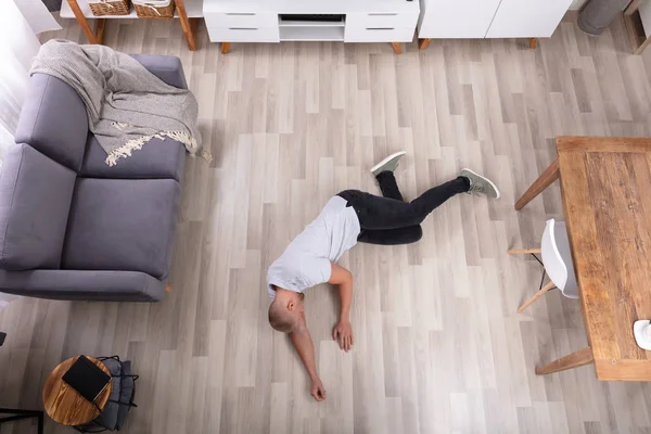 居間の床に横たわって意識不明の若い男 — ストック写真