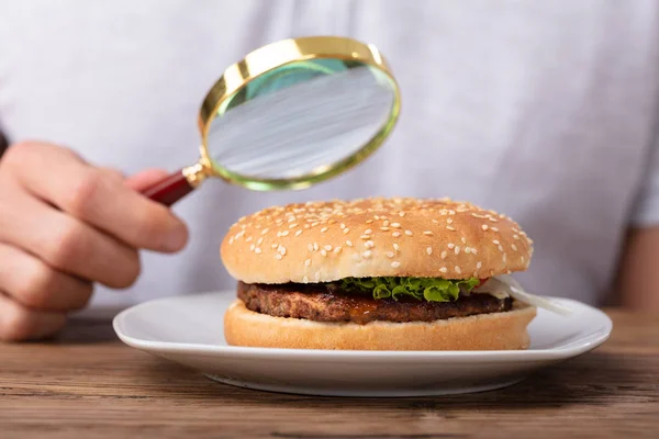 Männerhand Hält Lupe Mit Frischem Burger — Stockfoto