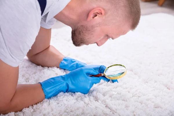 Side View Young Male Janitor Looking Carpet Magnifying Glass — Stock Photo, Image