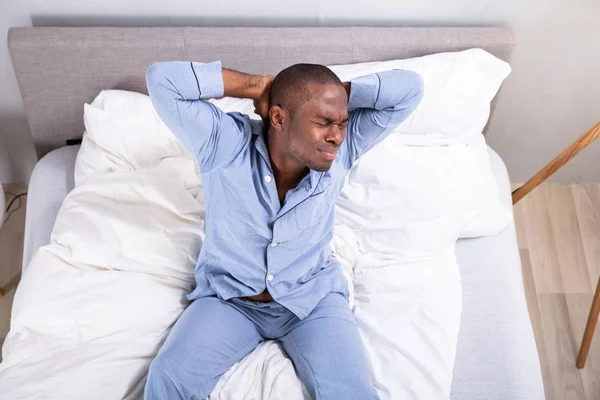 Peningkatan Pemandangan Pria Muda Yang Mengantuk Duduk Tempat Tidur — Stok Foto