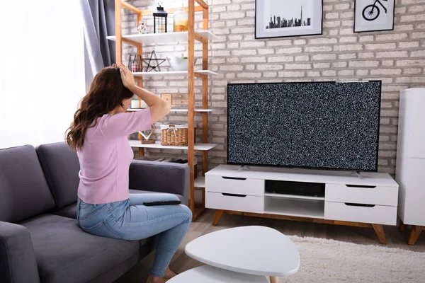 Frustrada Jovem Mulher Sentada Sofá Olhando Para Televisão Sem Sinal — Fotografia de Stock