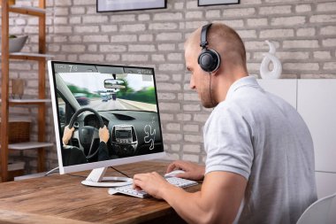 Araba oyunu bilgisayarda Resepsiyon üzerinde oynamak kulaklık ile genç adam