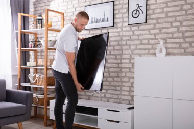 Genç yerleştirme yeni televizyon evde adam