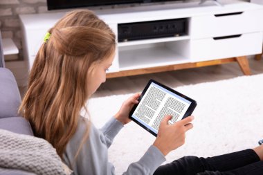E-kitap dijital tablet evde okuma bir kızın yakın çekim