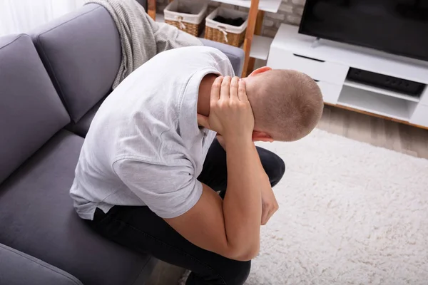 首の痛みに苦しむソファに座っている男のクローズアップ — ストック写真