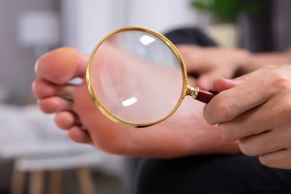 Gros Plan Main Homme Tenant Verre Grossissant Devant Ses Pieds — Photo