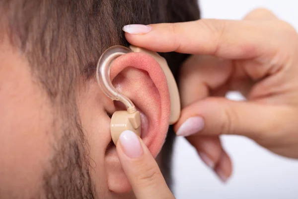 Close Doctor Hand Inserting Hearing Aid Male Patient Ear — Stock Photo, Image