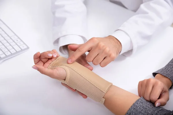 女性の手を骨折したを確認する医師の手のクローズ アップ — ストック写真