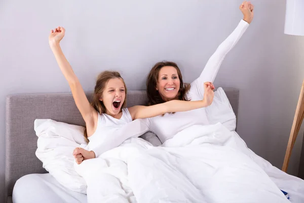 Gelukkig Moeder Met Haar Dochter Hun Armen Uitrekken Bed Slaapkamer — Stockfoto