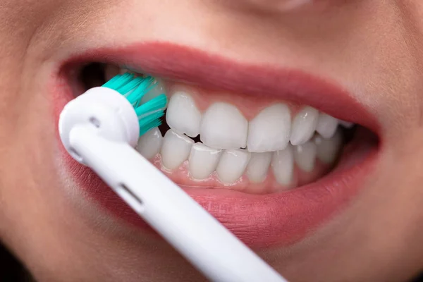Крупный План Женской Руки Чистящей Зубы Электрической Зубной Щеткой — стоковое фото