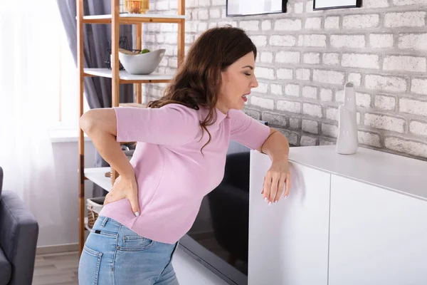 Side View Young Woman Suffering Backache Leaning Cabinet Dalam Bahasa — Stok Foto